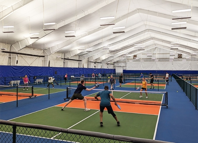 People playing pickleball on indoor courts